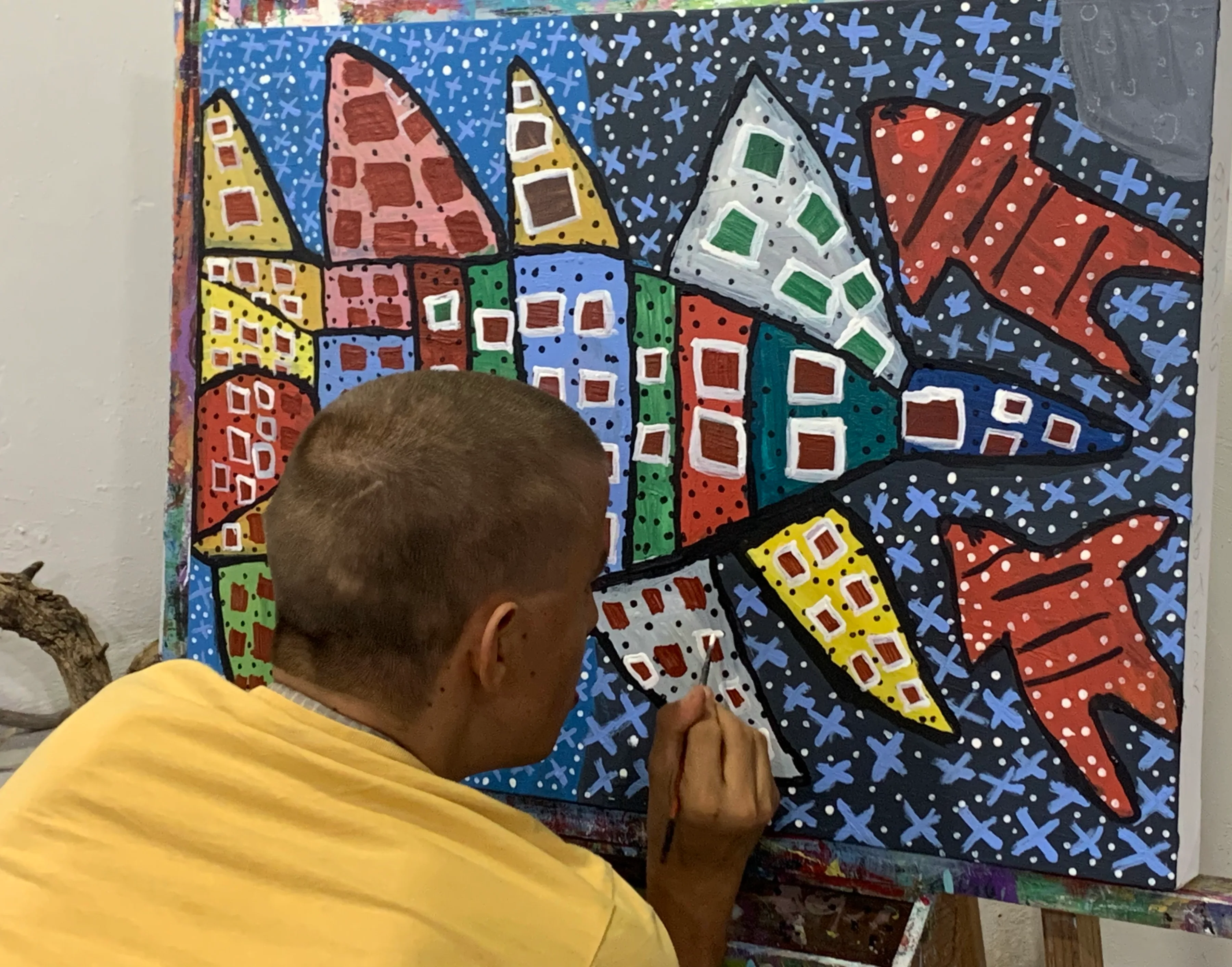 Alumna joven pintando una pieza abstracta y colorida