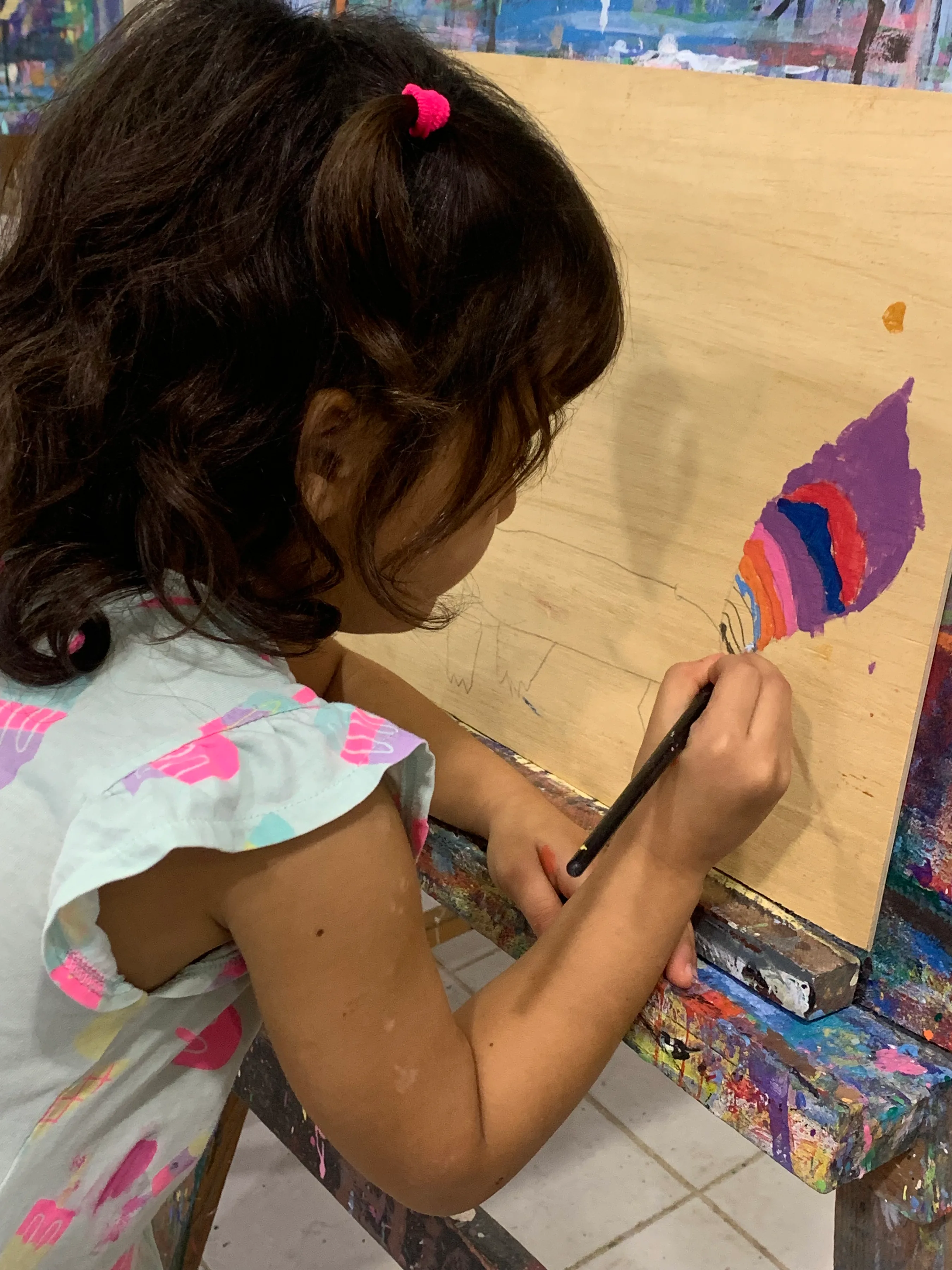 Niña dibujando y pintando en su caballete